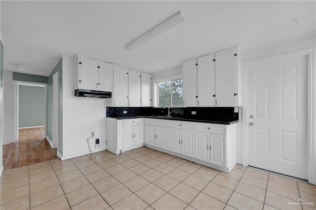 kitchen with white cabinetry, sink, decorative backsplash, and light tile patterned floors