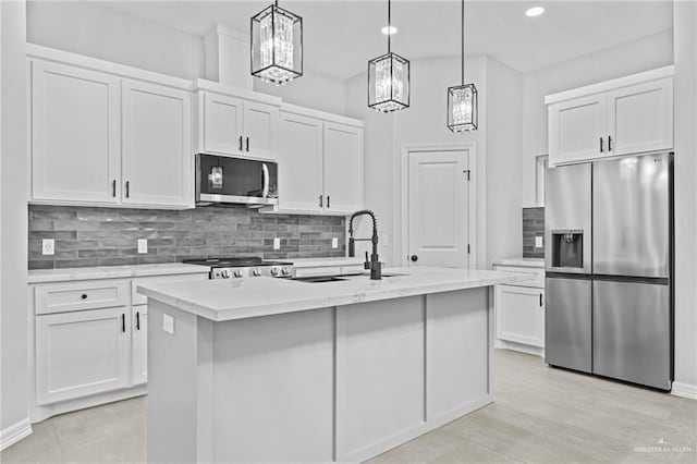 kitchen with a center island with sink, white cabinets, and stainless steel appliances