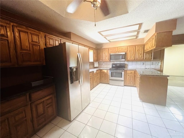 4407 Alejandro St, Mission, TX 78573 - kitchen with stainless steel appliances, a textured ceiling, light tile patterned floors, tasteful backsplash, and a peninsula