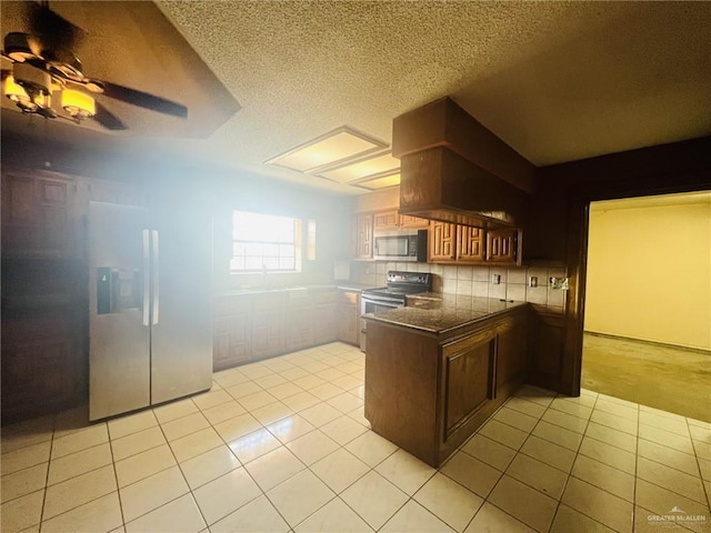 kitchen featuring decorative backsplash, appliances with stainless steel finishes, kitchen peninsula, ceiling fan, and light tile patterned flooring