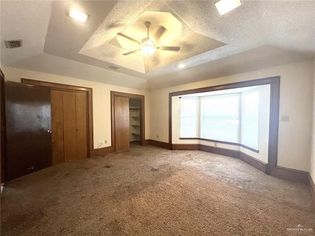 4407 Alejandro St, Mission, TX 78573 - unfurnished bedroom featuring a raised ceiling, carpet, multiple closets, ceiling fan, and a textured ceiling