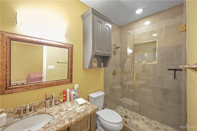 bathroom featuring toilet, a shower stall, recessed lighting, and vanity