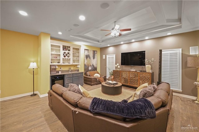 living area featuring light wood-style floors, wine cooler, wet bar, and baseboards