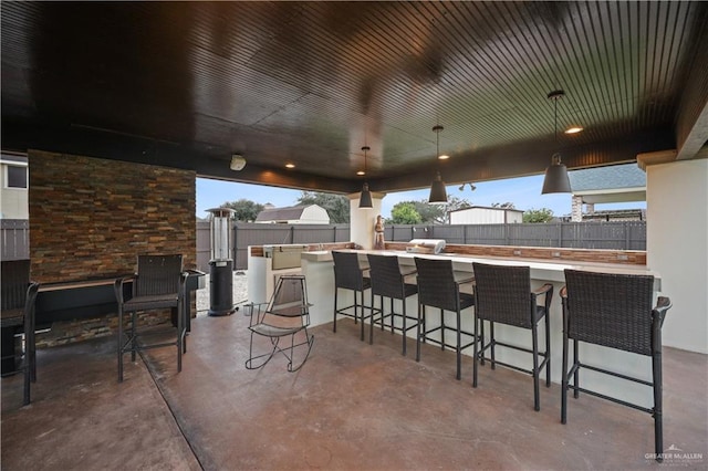 view of patio featuring outdoor wet bar and fence