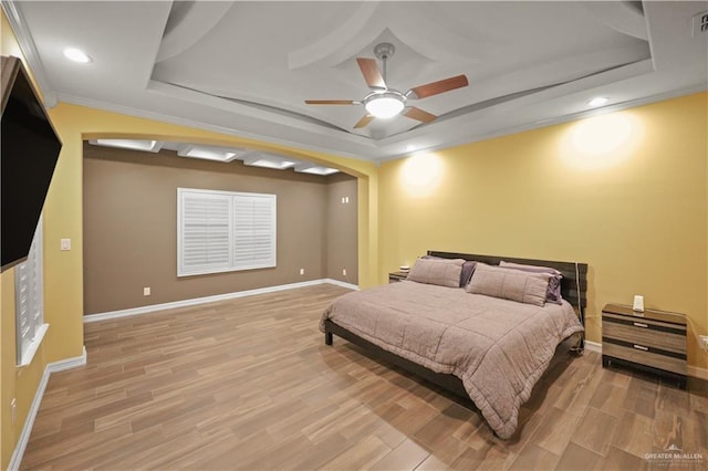 bedroom featuring a tray ceiling and light wood-style floors