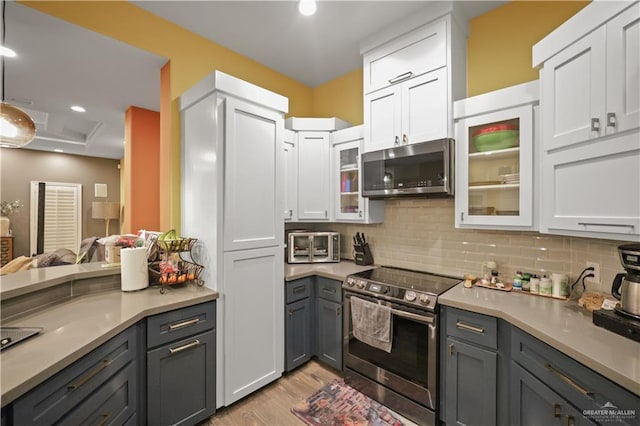 kitchen featuring white cabinetry, appliances with stainless steel finishes, light countertops, and decorative backsplash