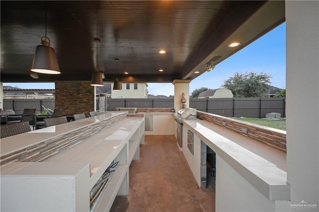 view of patio / terrace with exterior kitchen, outdoor dining area, a fenced backyard, and a grill