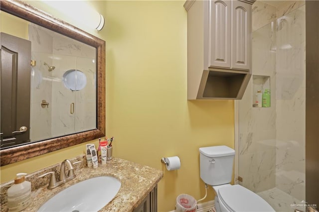 full bathroom featuring vanity, a marble finish shower, and toilet