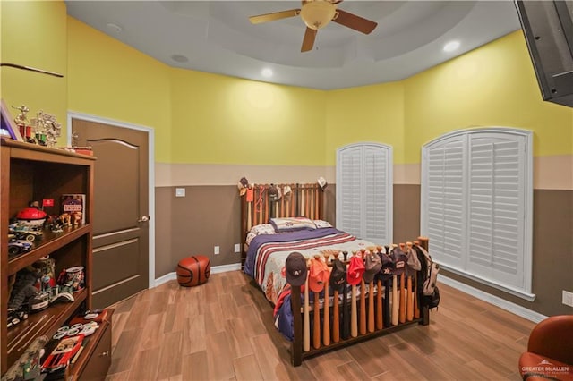 bedroom with ceiling fan, recessed lighting, wood finished floors, baseboards, and a raised ceiling