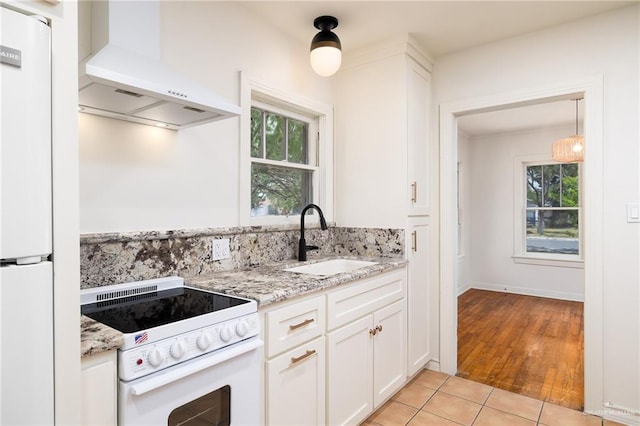 1315 Kendlewood Ave, Mcallen, TX 78501 - kitchen with white appliances, wall chimney exhaust hood, a sink, white cabinetry, and light stone countertops