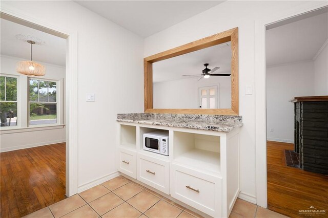 1315 Kendlewood Ave, Mcallen, TX 78501 - kitchen with white cabinets, light stone counters, baseboards, and white microwave