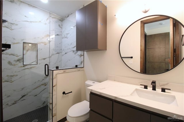 bathroom with vanity, toilet, and a shower with door