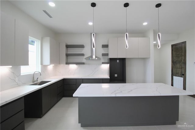 kitchen with backsplash, a center island, white cabinetry, and sink