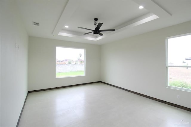 empty room with a raised ceiling and ceiling fan