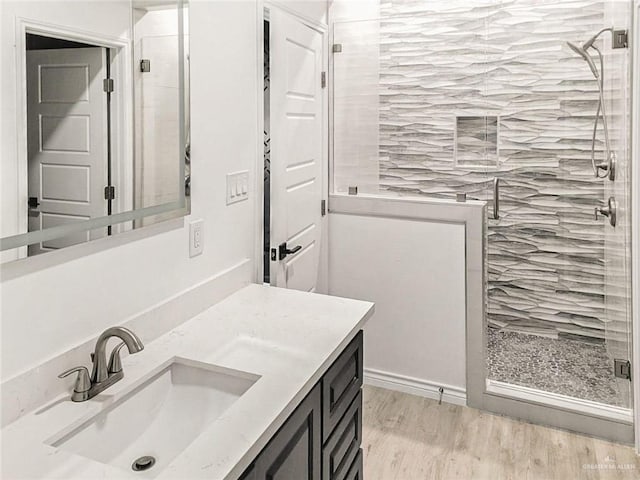 bathroom with vanity, wood-type flooring, and walk in shower