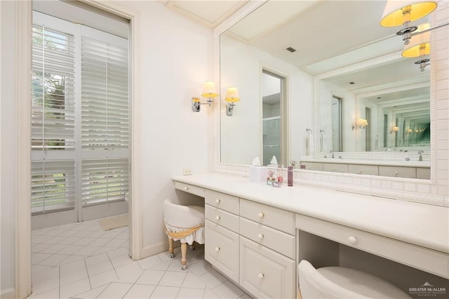 bathroom with tile patterned flooring, vanity, and a healthy amount of sunlight