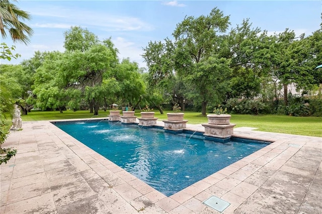 view of pool with a yard, pool water feature, and a patio