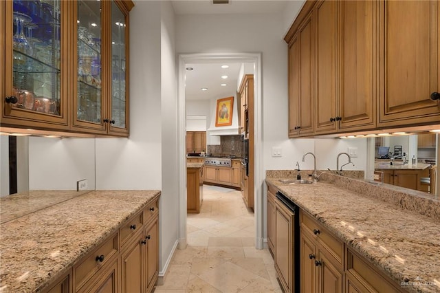 kitchen featuring light stone counters, sink, and stainless steel gas cooktop