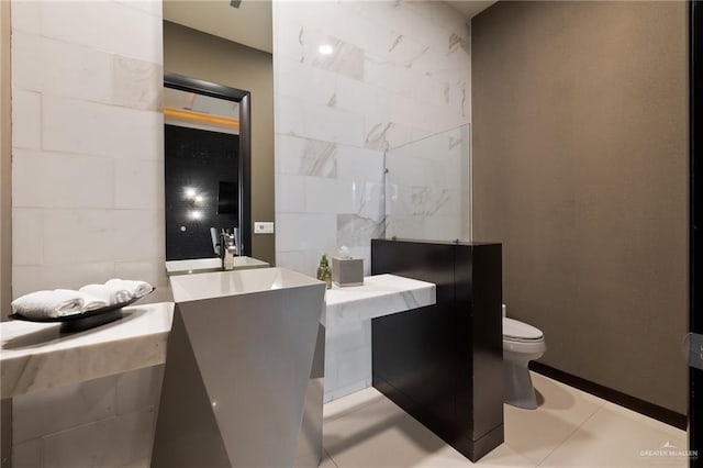 bathroom featuring sink, tile walls, tile patterned floors, and toilet