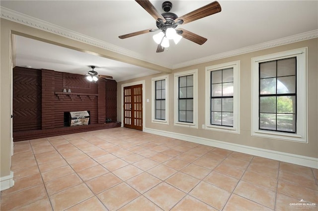 unfurnished living room featuring ceiling fan, crown molding, light tile patterned floors, and a brick fireplace