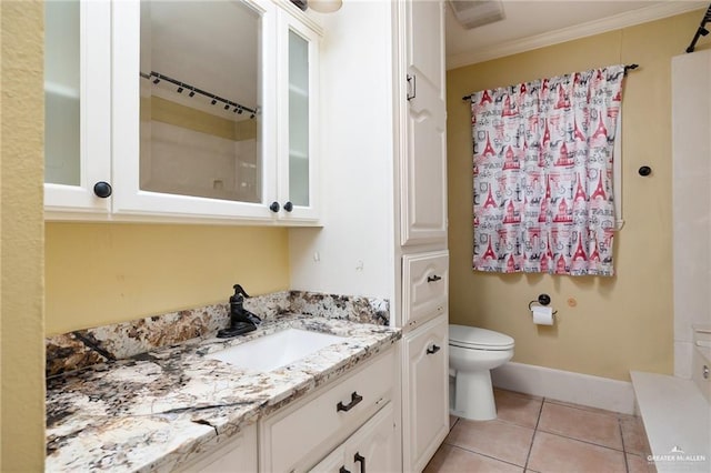 bathroom featuring toilet, tile patterned flooring, vanity, and ornamental molding