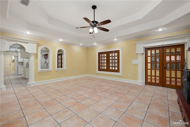 tiled empty room featuring a tray ceiling, ceiling fan, and french doors