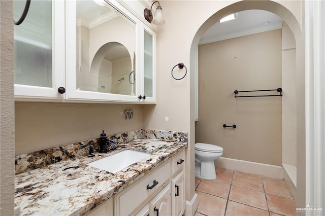 bathroom with toilet, vanity, tile patterned floors, and crown molding