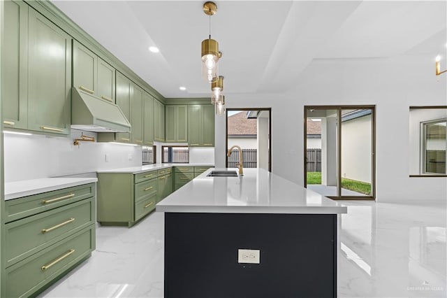 kitchen featuring a kitchen island with sink, sink, pendant lighting, and green cabinets