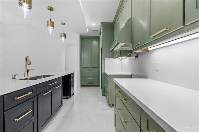 kitchen featuring green cabinets, decorative light fixtures, and sink