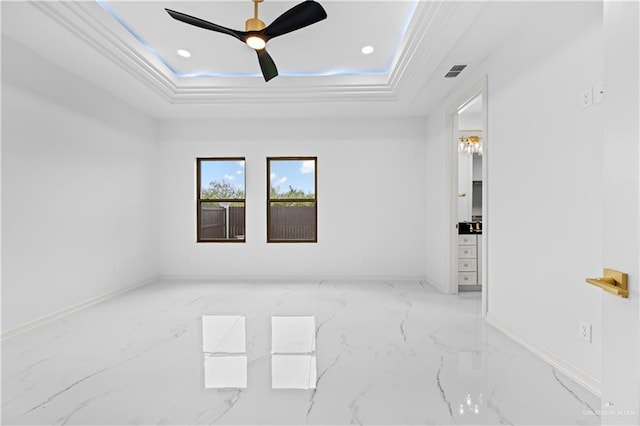 empty room with a raised ceiling, ceiling fan, and ornamental molding