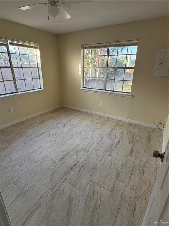 spare room featuring ceiling fan and a healthy amount of sunlight