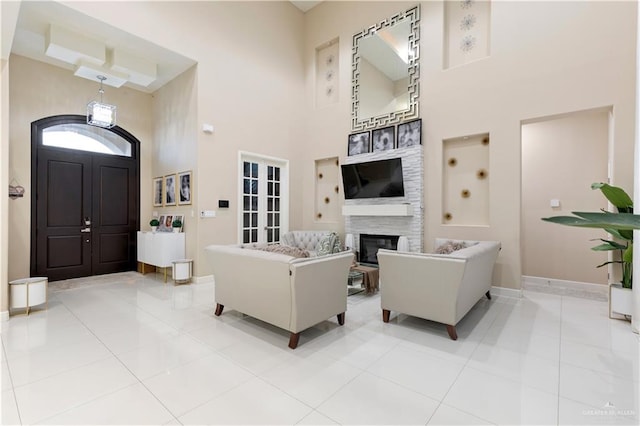 tiled living room with a high ceiling and french doors