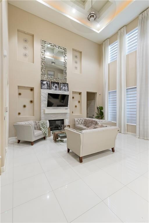 tiled living room featuring a high ceiling and ceiling fan