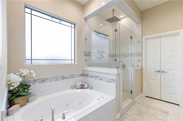 bathroom featuring tile patterned flooring and shower with separate bathtub