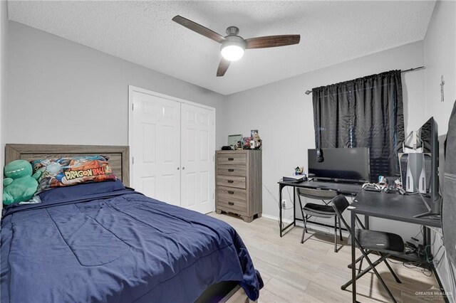 bedroom with baseboards, a ceiling fan, light wood-style flooring, a textured ceiling, and a closet