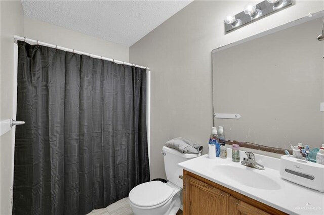 full bath featuring toilet, a textured ceiling, and vanity