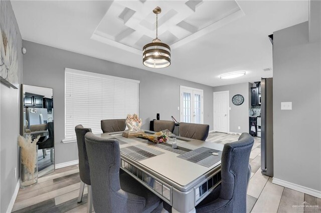 dining room with light wood-style flooring, baseboards, coffered ceiling, and french doors