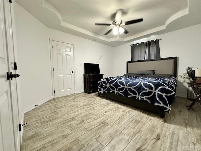 712 Bridget St, Weslaco, TX 78596 - bedroom featuring a tray ceiling, wood finished floors, and a ceiling fan