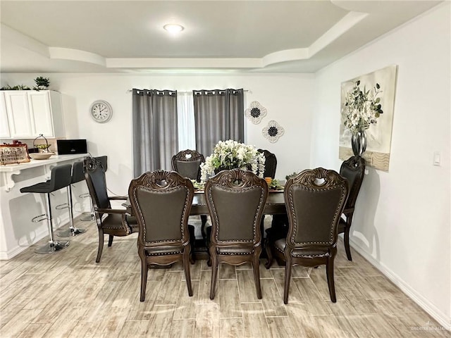 712 Bridget St, Weslaco, TX 78596 - dining space with a tray ceiling and light wood-type flooring