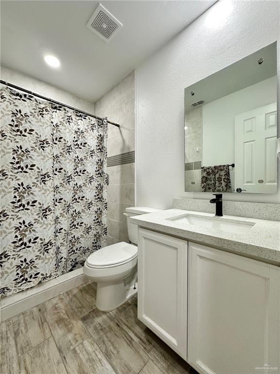 712 Bridget St, Weslaco, TX 78596 - bathroom with vanity, wood finished floors, and tiled shower