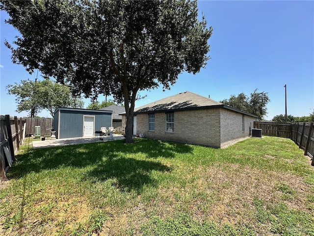 712 Bridget St, Weslaco, TX 78596 - rear view of property featuring a fenced backyard, an outbuilding, and brick siding