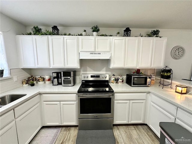712 Bridget St, Weslaco, TX 78596 - kitchen featuring stainless steel appliances, under cabinet range hood, white cabinetry, and light countertops
