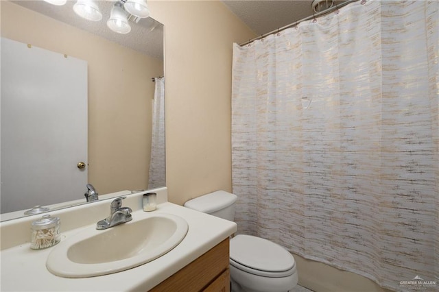 bathroom with vanity, toilet, and a textured ceiling