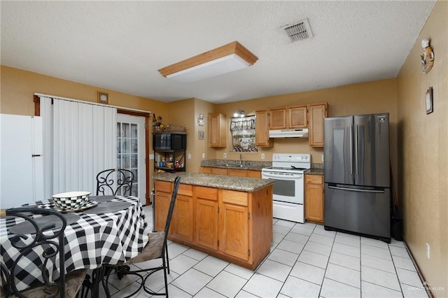 kitchen featuring sink, white appliances, light tile patterned floors, light stone counters, and a textured ceiling