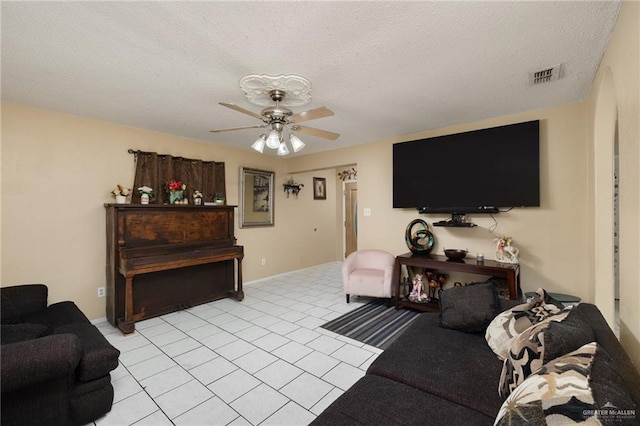 tiled living room featuring ceiling fan and a textured ceiling