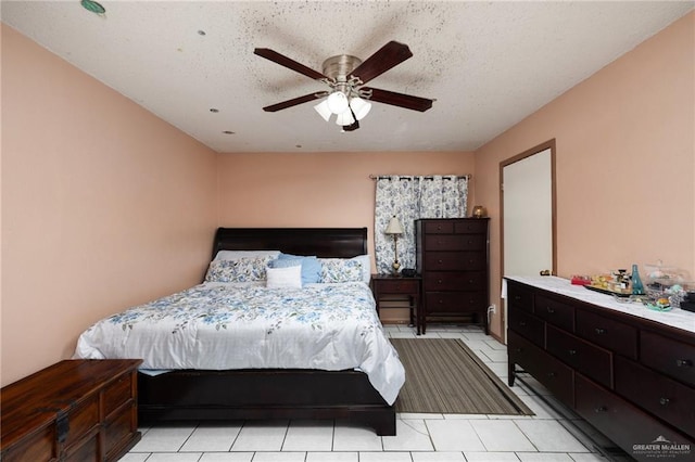 tiled bedroom with ceiling fan and a textured ceiling