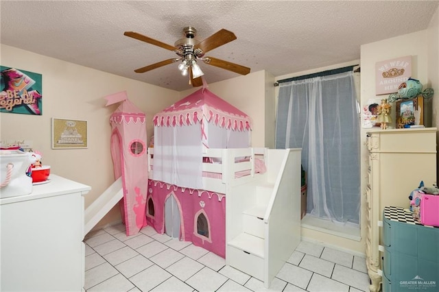 bathroom featuring ceiling fan, tile patterned floors, and a textured ceiling