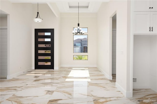 foyer with crown molding and an inviting chandelier