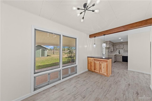 kitchen with light wood finished floors, tasteful backsplash, baseboards, a peninsula, and beam ceiling