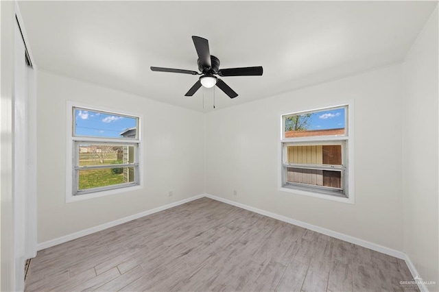 empty room featuring baseboards, ceiling fan, and light wood finished floors